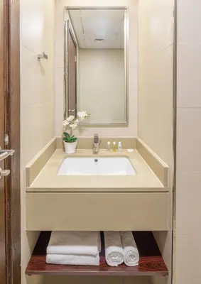 a bathroom with a sink and a mirror and towels at Silkhaus elegant studio with Burj Khalifa view and balcony in Dubai