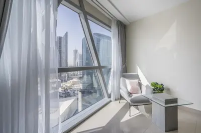 a living room with a large window with a chair and a table at HiGuests - Luxury Apartment in the Iconic Park Towers in Dubai