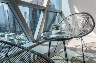 a table and chairs on a balcony with a view of the city at HiGuests - Luxury Apartment in the Iconic Park Towers in Dubai