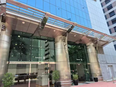 a building with a traffic light in front of it at Trinity Holiday Homes - Sheikh Zayed Road Right Next to Financial Center Metro Station Exit 1 in Dubai