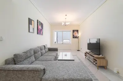 a living room with a couch and a flat screen tv at Trinity Holiday Homes - Sheikh Zayed Road Right Next to Financial Center Metro Station Exit 1 in Dubai