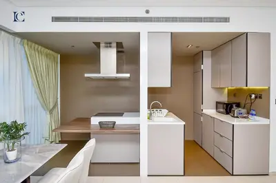 a kitchen with white cabinets and a dining table at Luxury Escapes - 1BR Apt with Balcony - West Avenue Marina in Dubai