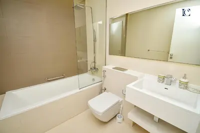 a bathroom with a sink and a toilet and a mirror at Luxury Escapes - 1BR Apt with Balcony - West Avenue Marina in Dubai