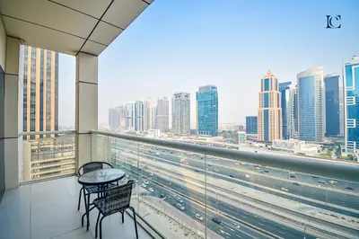 a balcony with a table and chairs and a view of a city at Luxury Escapes - 1BR Apt with Balcony - West Avenue Marina in Dubai