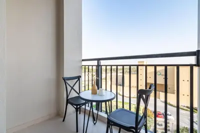 a small table and chairs on a balcony with a view at GuestReady - The Wandering Oasis in Town Square in Dubai