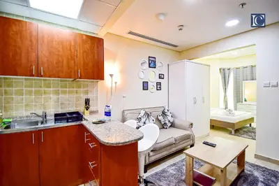 a kitchen and a living room with a couch at Luxury Escapes - Budget Studio - New Dubai Gate 2 JLT in Dubai