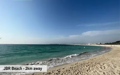 a beach with people swimming in the water at Luxury Escapes - Budget Studio - New Dubai Gate 2 JLT in Dubai