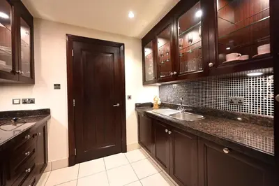 a large kitchen with wooden cabinets and a sink at Newly furnished. Cozy apartment. Quite location. in Dubai