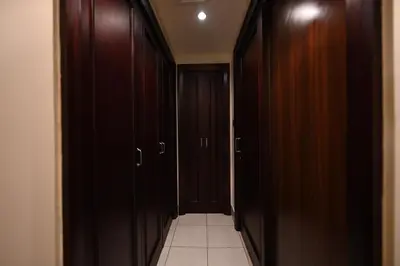 a hallway with dark wood cabinets and a tile floor at Newly furnished. Cozy apartment. Quite location. in Dubai