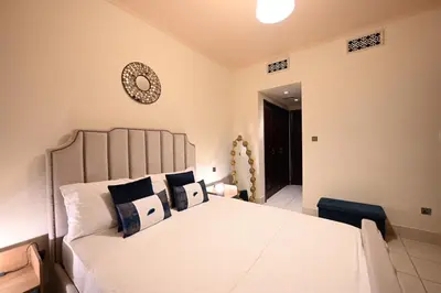 a bedroom with a white bed and a clock on the wall at Newly furnished. Cozy apartment. Quite location. in Dubai