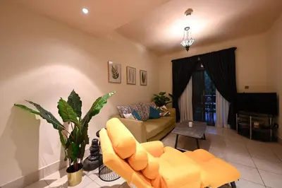 a living room with a yellow couch and a piano at Newly furnished. Cozy apartment. Quite location. in Dubai