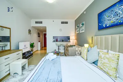 a bedroom with a large bed and a living room at Luxury Escapes - New Lake View Studio in JLT - near Metro in Dubai