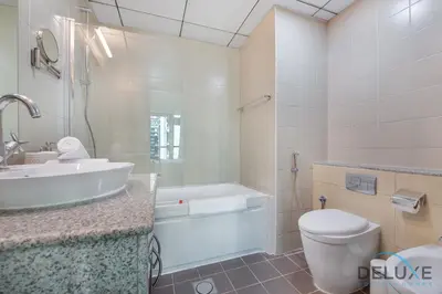 a bathroom with a sink and a tub and a toilet at Full Marina and Ain Dubai Wheel View 1BR at The Point Dubai Marina by Deluxe Holiday Homes in Dubai