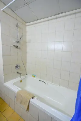 a white bath tub in a bathroom with a shower at Luxury Escapes - Studio near Ibn Battuta Mall & Metro - MOG 193 Discovery Gardens in Dubai