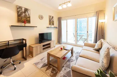 a living room with a couch and a tv at Luxury Escapes - Elegant and spacious 1bed with 2 balconies in JLT in Dubai