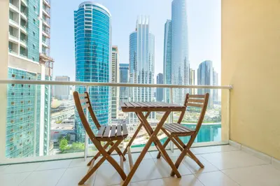 a table and chairs on a balcony with a view of the city at Luxury Escapes - Elegant and spacious 1bed with 2 balconies in JLT in Dubai