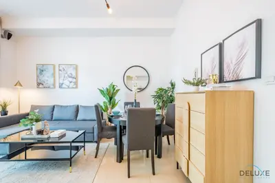 a living room with a blue couch and a table at Captivating 1BR at DEC Towers Dubai Marina by Deluxe Holiday Homes in Dubai