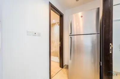 a kitchen with a stainless steel refrigerator in a hallway at Captivating 1BR at DEC Towers Dubai Marina by Deluxe Holiday Homes in Dubai