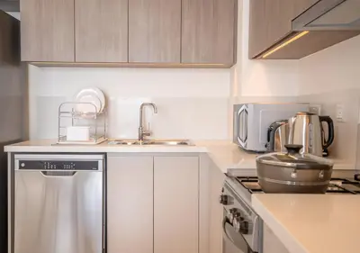 a kitchen with a sink and a stove top oven at Nasma Luxury Stays - Elegant Condo With City Views And Dubai Skyline in Dubai
