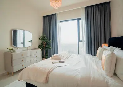 a bedroom with a white bed and a mirror at Nasma Luxury Stays - Elegant Condo With City Views And Dubai Skyline in Dubai