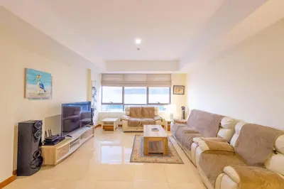 a living room with a couch and a tv at Luxury Escapes - Stylish 1BR - Murad Tower - Close to the Emirates Mall in Dubai