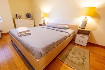 a bedroom with a large bed with white sheets and a lamp at Luxury Escapes - Stylish 1BR - Murad Tower - Close to the Emirates Mall in Dubai