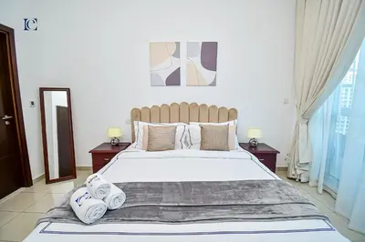 a bedroom with a large bed with towels on it at Luxury Escapes - 1BR Home with Stunning Marina View - Bay Central Marina in Dubai