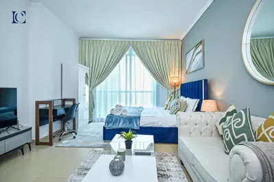 a living room with a couch and a bed at Luxury Escapes - Lake View Brand New Studio in X1 Tower JLT in Dubai