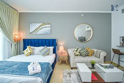 a bedroom with two beds and a couch and a mirror at Luxury Escapes - Lake View Brand New Studio in X1 Tower JLT in Dubai