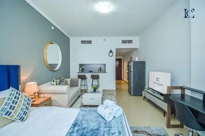 a room with a bed and a living room at Luxury Escapes - Lake View Brand New Studio in X1 Tower JLT in Dubai