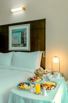 a table with two plates of food on a bed at TIME Oak Hotel & Suites in Dubai