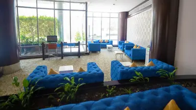 a waiting room with blue chairs and a television at Signature Hotel Apartments and Spa in Dubai