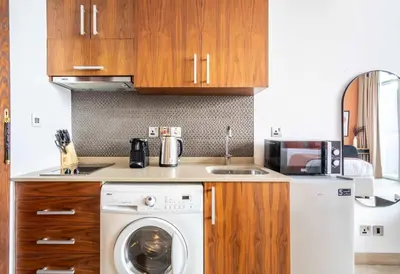 a kitchen with a washing machine and a sink at Silkhaus modern studio with Burj Khalifa view in DIFC in Dubai