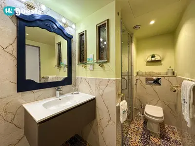 a bathroom with a sink and a toilet and a mirror at HiGuests - Royal 2BR Apt with Maid's Room Near Burj Khalifa in Dubai