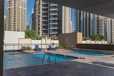 a swimming pool in a city with tall buildings at HiGuests - Royal 2BR Apt with Maid's Room Near Burj Khalifa in Dubai