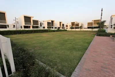 a large grassy yard in front of some buildings at Upgraded spacious 3BR+Maid Villa in Dubai
