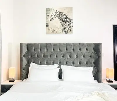 a bedroom with a large bed with a gray headboard at Luxury Room with Marina view close to JBR Beach and Metro with Shared Kitchen in Dubai