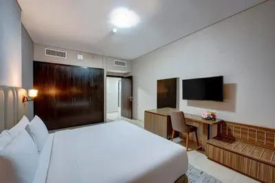 a bedroom with a bed and a desk and a television at Regency Luxury Suites in Dubai