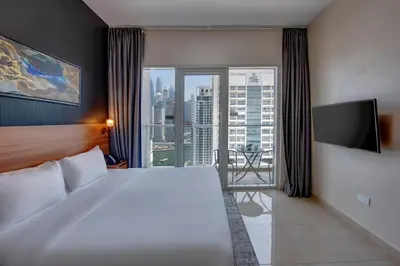 a hotel room with a large bed and a large window at Regency Luxury Suites in Dubai