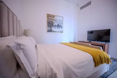 a bedroom with a bed with a yellow blanket on it at 3BR Haven with Burj Views by MagnoliasVHR in Dubai