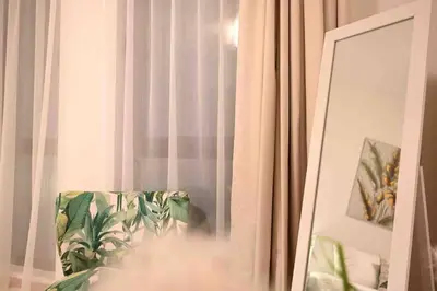 a room with a curtain and a chair and a mirror at Brand new furniture . Close to Dubai Mall. in Dubai