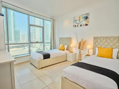 a bedroom with two beds and a large window at Wonderful two bed room with full marina view in Dubai