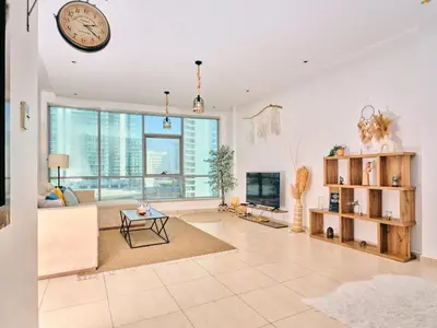 a large living room with a clock on the ceiling at Wonderful two bed room with full marina view in Dubai