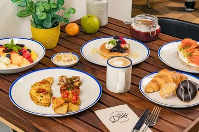a wooden table topped with plates of breakfast foods at Rove Expo City in Dubai