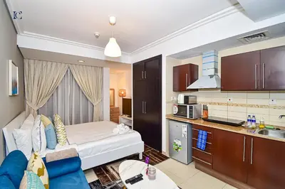 a small room with a bed and a kitchen at Luxury Escapes - Cozy Studio with Balcony near Metro - Goldcrest 2 JLT in Dubai