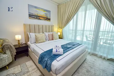 a bedroom with a large bed and a large window at Brand New Studio Apt - Near JLT Metro in Dubai