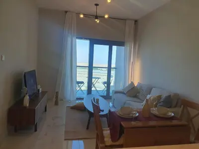 a living room with a couch and a table at Cozy 1-bedroom apartment in Dubai South with Pool in Dubai