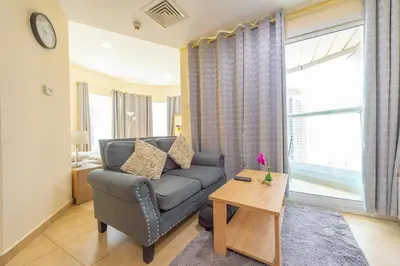 a living room with a couch and a table at Luxury Escapes - Modern Budget studio with balcony in JLT! in Dubai