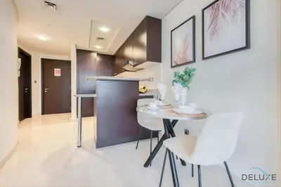 a kitchen with a table and chairs in a room at Special Rate Cozy Studio with Balcony Near Attractions by Deluxe Holiday Homes in Dubai
