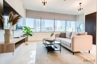 a living room with a couch and a table at Special Rate Cozy Studio with Balcony Near Attractions by Deluxe Holiday Homes in Dubai